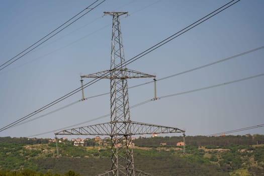 High voltage towers with sky background. Power line support with wires for electricity transmission. High voltage grid tower with wire cable at distribution station. Energy industry, energy saving.