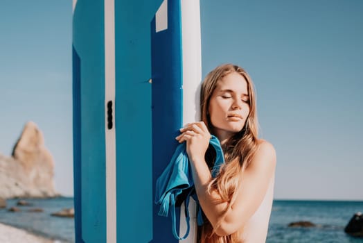 Close up shot of happy young caucasian woman looking at camera and smiling. Cute woman portrait in bikini posing on a volcanic rock high above the sea