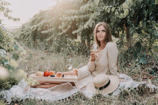 Picnic and wine tasting at sunset in the hills of Italy, Tuscany. Vineyards and open nature in the summer. Romantic dinner, fruit and wine.