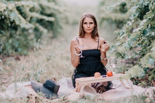 Picnic and wine tasting at sunset in the hills of Italy, Tuscany. Vineyards and open nature in the summer. Romantic dinner, fruit and wine.