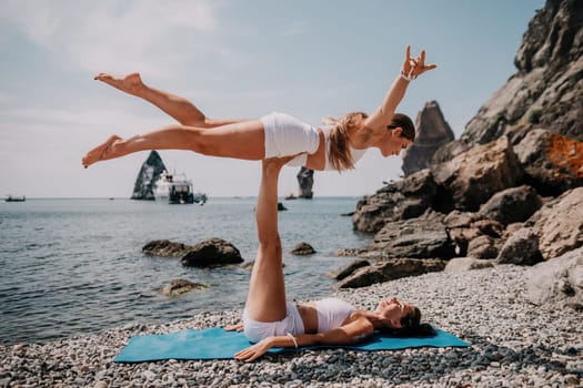 Woman sea yoga. Back view of free calm happy satisfied woman with long hair standing on top rock with yoga position against of sky by the sea. Healthy lifestyle outdoors in nature, fitness concept.