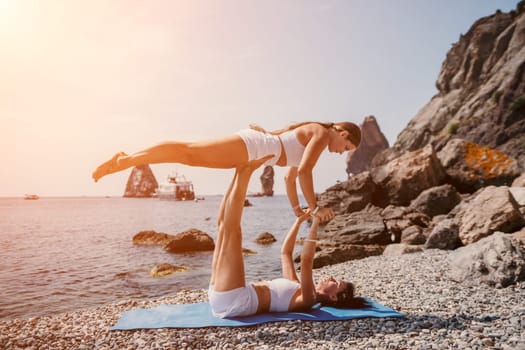 Woman sea yoga. Back view of free calm happy satisfied woman with long hair standing on top rock with yoga position against of sky by the sea. Healthy lifestyle outdoors in nature, fitness concept.