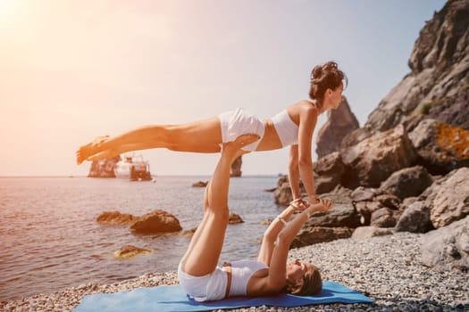 Woman sea yoga. Back view of free calm happy satisfied woman with long hair standing on top rock with yoga position against of sky by the sea. Healthy lifestyle outdoors in nature, fitness concept.