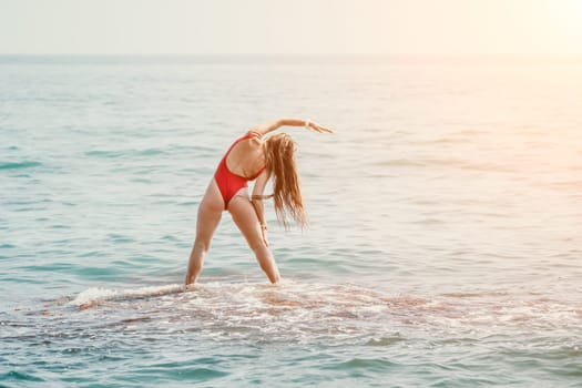 Woman sea yoga. Back view of free calm happy satisfied woman with long hair standing on top rock with yoga position against of sky by the sea. Healthy lifestyle outdoors in nature, fitness concept.