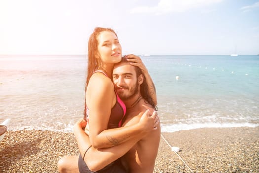 Close up shot of beautiful young caucasian woman with black hair and freckles looking at camera and smiling. Cute woman portrait in a pink bikini posing on a volcanic rock high above the sea