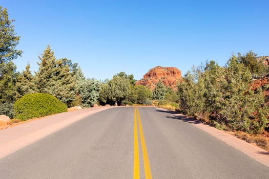 Long Straight Road Leading Towards Red Rock Mountain Butte Of Sedona, Arizona, USA Within Coconino National Forest. Beautiful Scenic Landscape. Attraction, Spiritual Place. Horizontal Plane