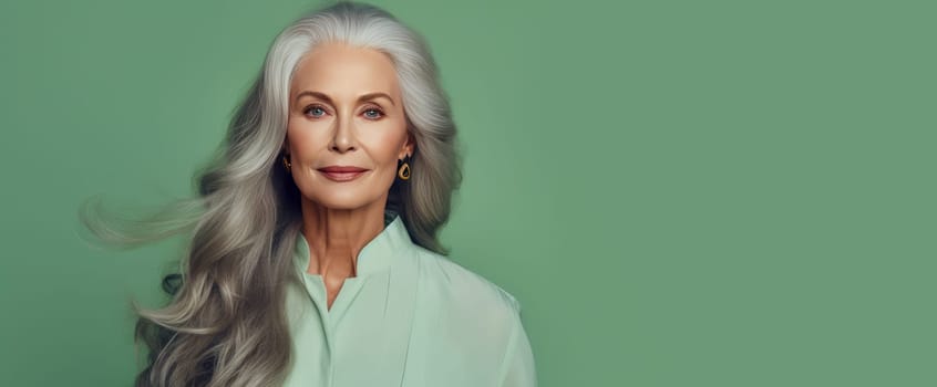 Elegant, smiling, elderly, chic, woman with gray long hair and perfect skin, on green background, banner. Advertising of cosmetic products, spa treatments, shampoos and hair care products, dentistry and medicine, perfumes and cosmetology for women.