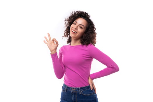 young curly promoter woman dressed in a lilac turtleneck gesturing with her hands.