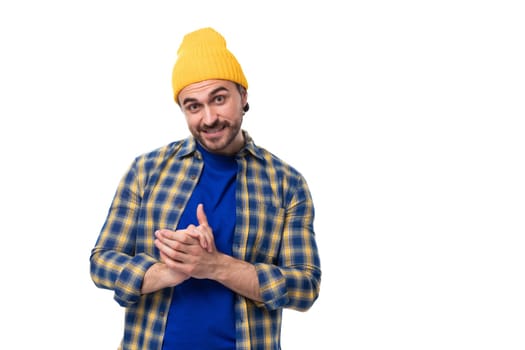 cute positive young hipster man in cap and shirt on white background with copy space.