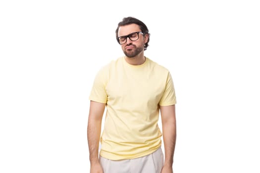 young brutal brunette man in a T-shirt on a white background with copy space.
