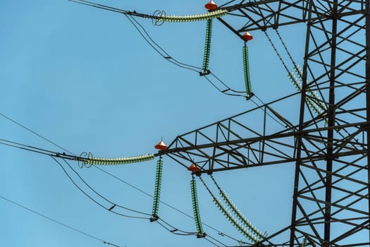 High voltage towers with sky background. Power line support with wires for electricity transmission. High voltage grid tower with wire cable at distribution station. Energy industry, energy saving.