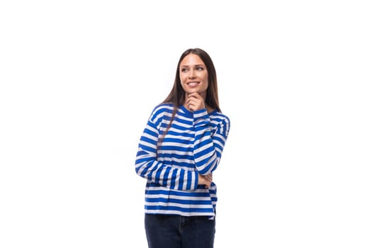 young slender european brunette woman dressed in a striped blue sweater on a white background.