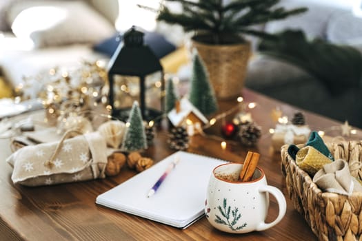 Pen on notepad at home on winter holidays xmas. Goals plans make to do and wish list for new year christmas concept,l writing in notebook. Christmas decoration, gift boxes.