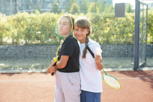 Two girls with badminton rackets on the football field. High quality photo