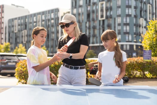 Family playing table tennis in the summer outdoors. High quality photo