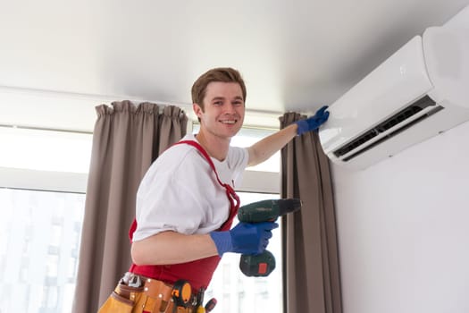 the worker connecting a new air conditioner unit.