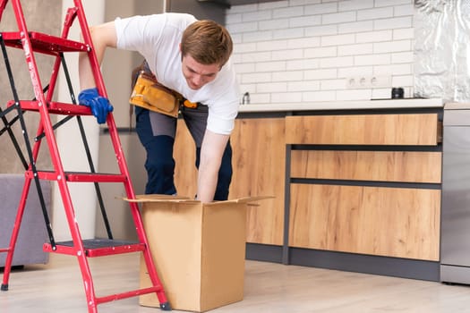 moving, people and real estate concept - happy smiling man holding boxes with stuff at new home.