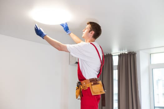 man changing led ceiling lamp in new house.