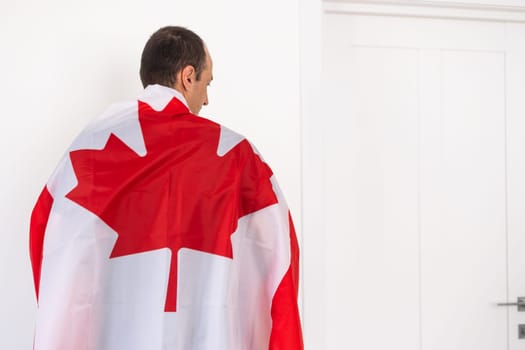 Young man with Canadian flag isolated on white. High quality photo