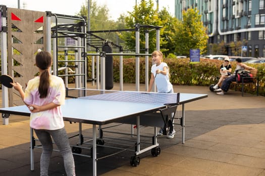 Photography of table tennis area in the public park. Street ping-pong sports competitions in spring day. Lifestyles of big city. People playing taBle tennis actively. High quality photo