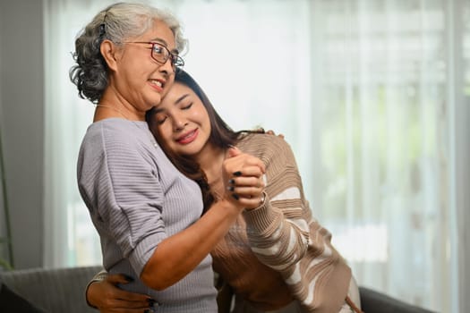 Loving adult daughter hugging happy mature mother. International hug day concept.