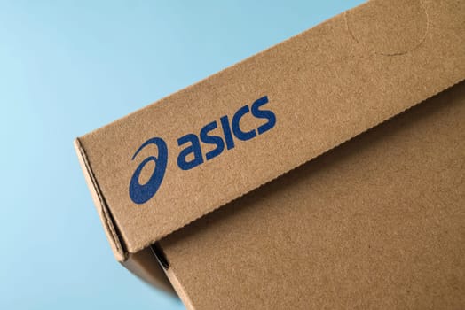 Antalya, Turkey - November 28, 2023: Sport shoe box with Asics logo printed. on blue background