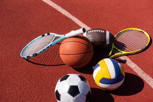 Set of sport equipment, soccer basketball balls and tennis rackets.