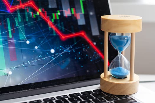 Time is money, make money and time management business and technology concept, hourglass on laptop keyboard macro view. deadline idea, symbol, concept. High quality photo