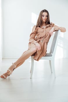 Portrait of a beautiful slender woman in a beige dress