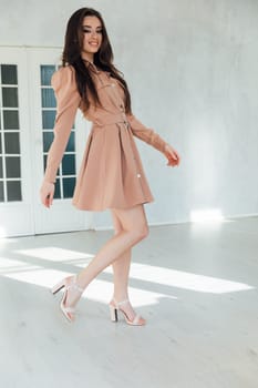 Portrait of a beautiful slender woman in a beige dress