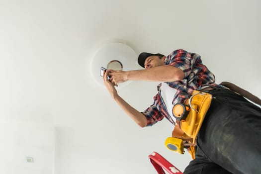 electrician installing led light bulbs in ceiling lamp. High quality photo