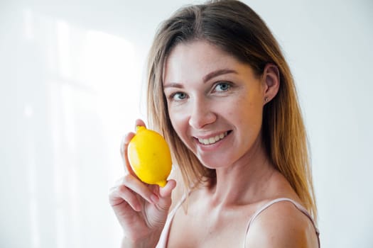 woman holding yellow lemons and smiling