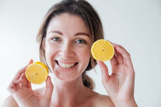 woman holding yellow lemons and smiling