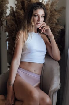 Portrait of slender woman in lingerie in bedroom