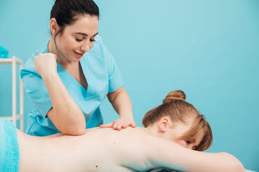 Masseuse doing a therapeutic back massage
