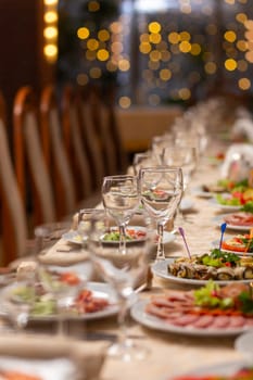 Served festive table with snacks, glasses, glasses, cutlery and napkins for a banquet on the occasion of a wedding or birthday or Christmas or other bright event in the restaurant