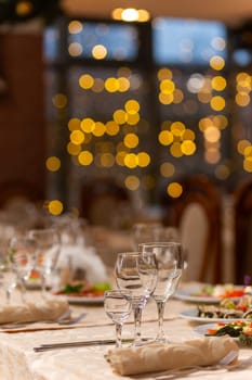 Served festive table with snacks, glasses, glasses, cutlery and napkins for a banquet on the occasion of a wedding or birthday or Christmas or other bright event in the restaurant