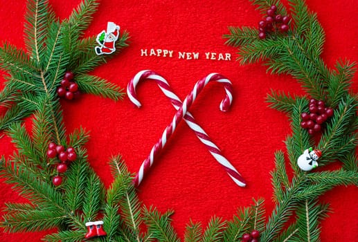Christmas tree and candy on a red background with the words Happy New Year. Closeup