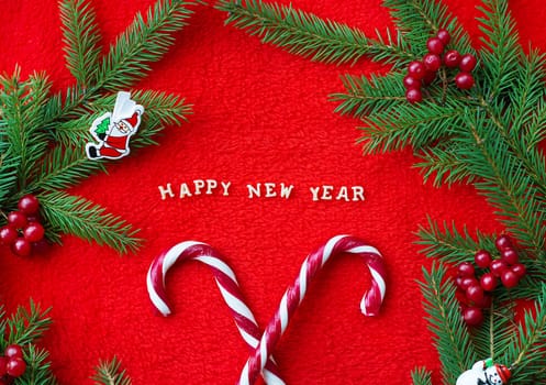 Christmas tree and candy on a red background with the words Happy New Year Postcard.