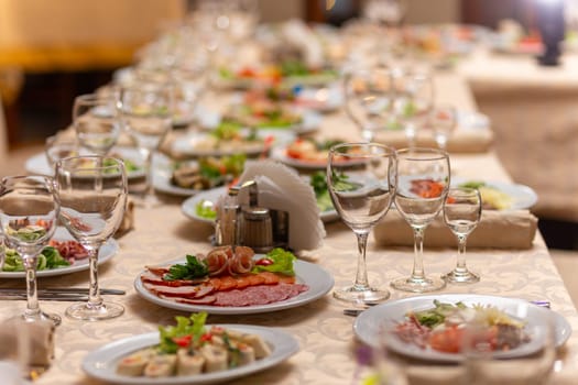 Served festive table with snacks, glasses, glasses, cutlery and napkins for a banquet on the occasion of a wedding or birthday or Christmas or other bright event in the restaurant