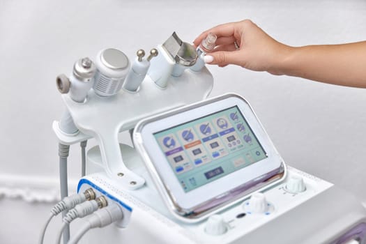 female beautician using cosmetology equipment in modern aesthetic clinic.