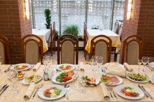 Served festive table with snacks, glasses, glasses, cutlery and napkins for a banquet on the occasion of a wedding or birthday or Christmas or other bright event in the restaurant