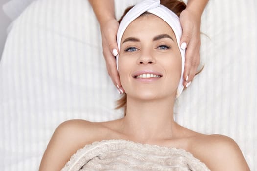 Beautiful woman getting face massage treatment in beauty salon. girl enjoys this procedure.