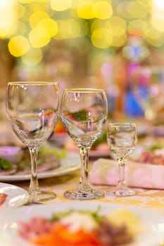 Served festive table with snacks, glasses, glasses, cutlery and napkins for a banquet on the occasion of a wedding or birthday or Christmas or other bright event in the restaurant