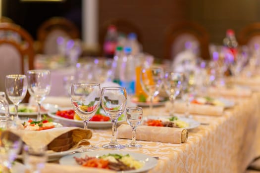 Served festive table with snacks, glasses, glasses, cutlery and napkins for a banquet on the occasion of a wedding or birthday or Christmas or other bright event in the restaurant