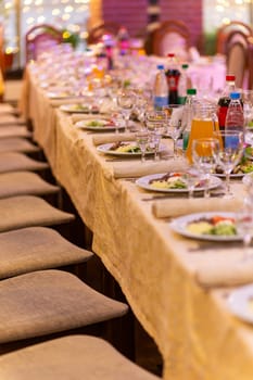 Served festive table with snacks, glasses, glasses, cutlery and napkins for a banquet on the occasion of a wedding or birthday or Christmas or other bright event in the restaurant