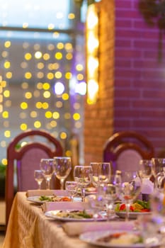 Served festive table with snacks, glasses, glasses, cutlery and napkins for a banquet on the occasion of a wedding or birthday or Christmas or other bright event in the restaurant