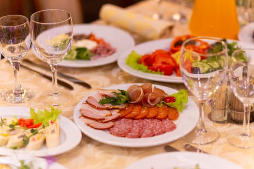 Served festive table with snacks, glasses, glasses, cutlery and napkins for a banquet on the occasion of a wedding or birthday or Christmas or other bright event in the restaurant