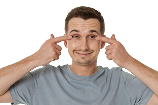 portrait of young funny man grimacing on white background
