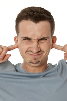 Young annoyed caucasian man in t-shirt closed eyes cover ears with hands fingers on white background